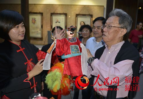 王蒙（右）向传承人学习表演晋江掌中木偶戏。 樊山 摄