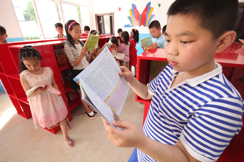 孩子们正╳在开放式阅览室认真阅读书籍