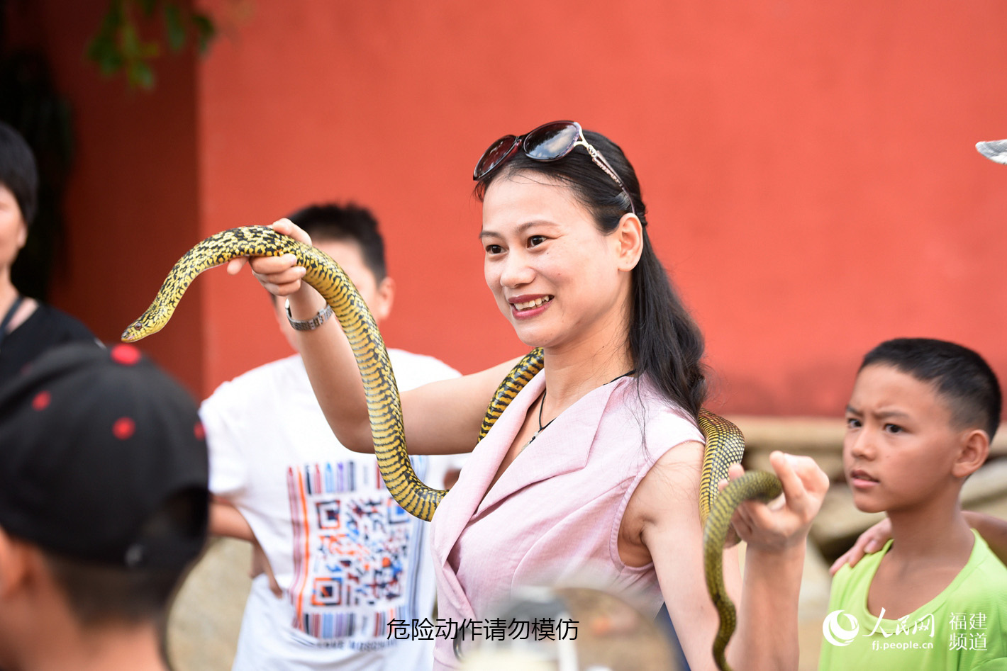 不少第一次來的游客被當地氛圍感染，也開始與蛇親近、合影。余杉芳攝