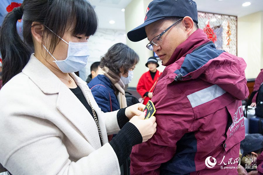 “讓我親手為你戴上出征的臂章。”妻子飽含深情，為丈夫鼓勁。她的愛人叫涂思義，是來自福建中醫藥大學附屬第二人民醫院呼吸科的主治醫師。 焦艷攝