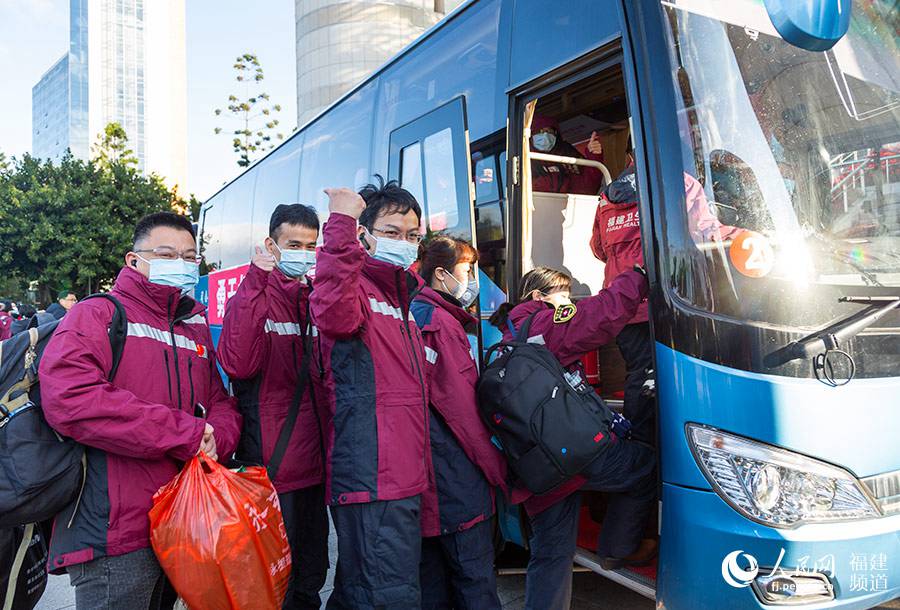 醫療隊隊員陸續登車，攢住拳頭，示意勇氣和信念。 焦艷攝