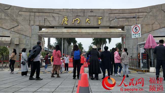 廈門大學於1月24日起暫停對游客開放，部分游客隻能在門口拍照留念。陳博攝