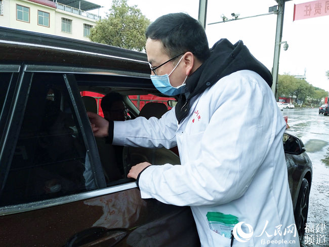 工作人員在國道205線武平岩前鎮檢查點檢測司乘人員體溫 肖文秀攝