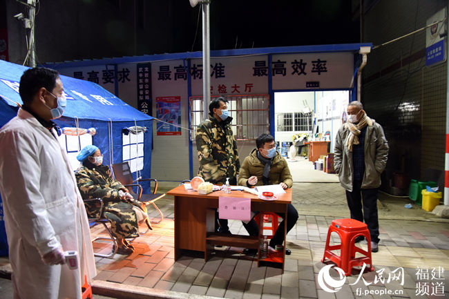 工作人員在省際國道東留背寨村檢查點檢測司乘人員體溫 肖文秀攝