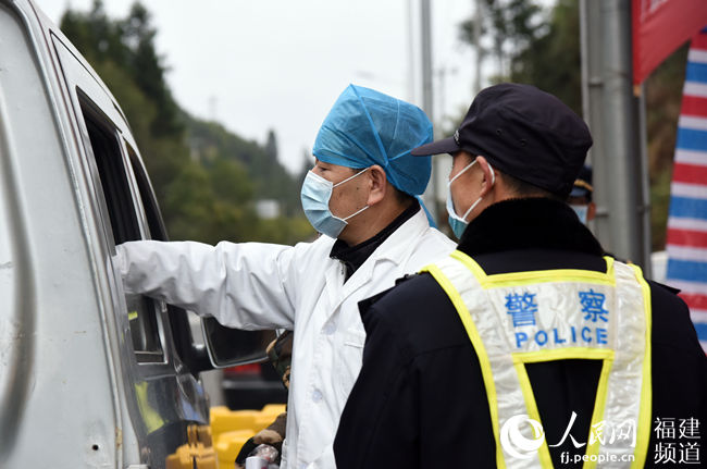 工作人員在省際國道東留背寨村檢查點檢測司乘人員體溫 肖文秀攝