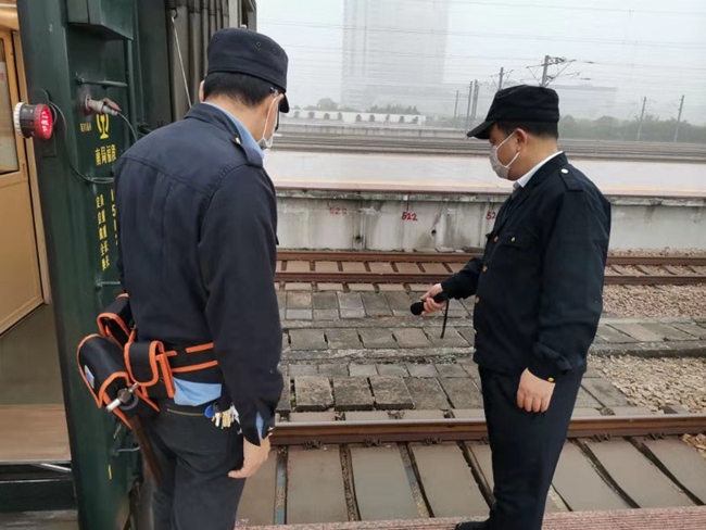 列車始發前尾部制動軟管、總風管吊起狀態檢查。 江能斌攝