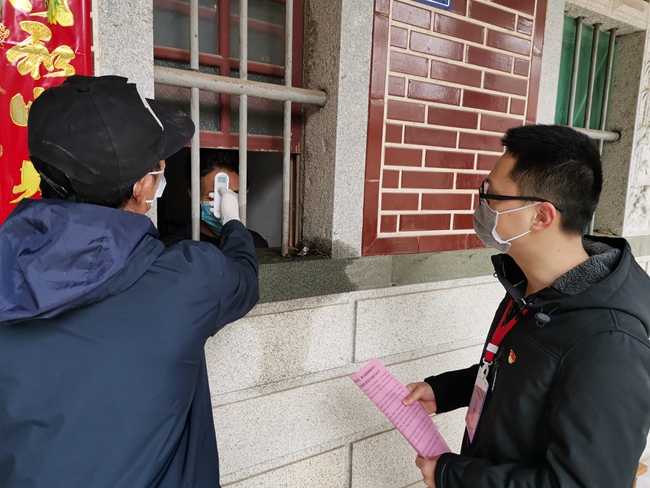 桥隧中心驻大厦村寇贵萍和村干部正在给隔离人员测量体温，入户宣传。刘紫燕摄