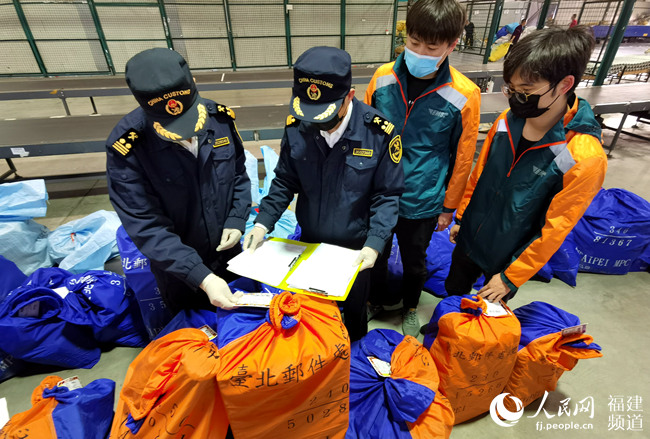 榕城海關駐郵局辦事處對首批通過臨時郵路進境的轉關郵件進行“零延時”驗放。福州海關供圖