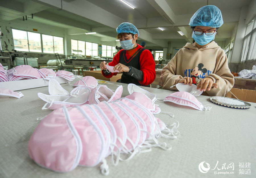 3月4日，福建晉江巢生公司口罩生產線，工人在整理即將在包裝的口罩。 董嚴軍攝