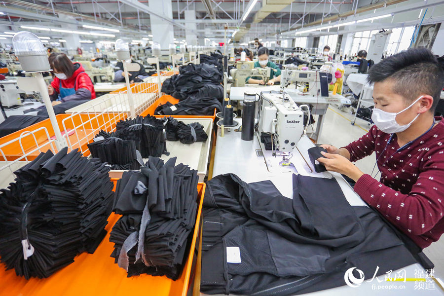 3月5日，福建晉江七匹狼服裝生產車間，工人在生產西褲。 董嚴軍攝