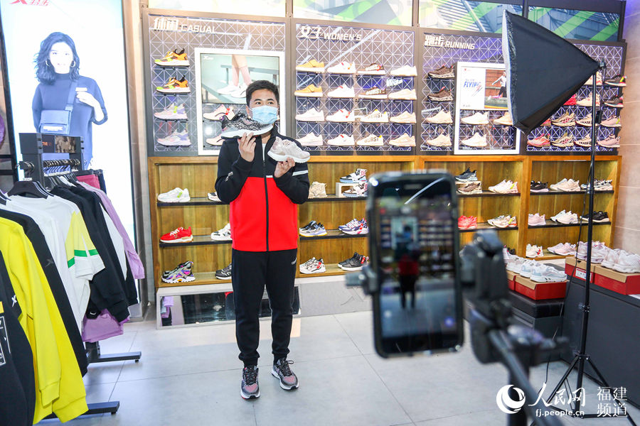 3月12日，福建晉江特步專賣店，店員正在線上直播賣鞋。 董嚴軍攝