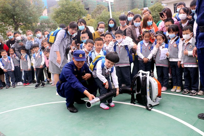 福建省森林消防總隊南平支隊福安大隊班長宗興振正在輔助小朋友體驗用風力滅火機吹磚塊。福安市森林消防大隊供圖