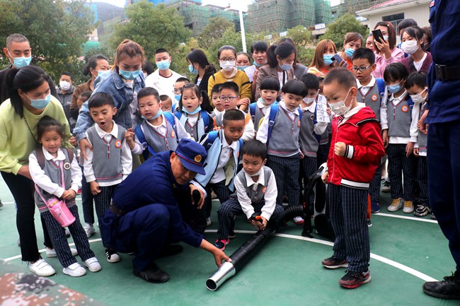 幼兒園小朋友在指戰員的幫助下，親身體會風力滅火機的操作使用。福安市森林消防大隊供圖