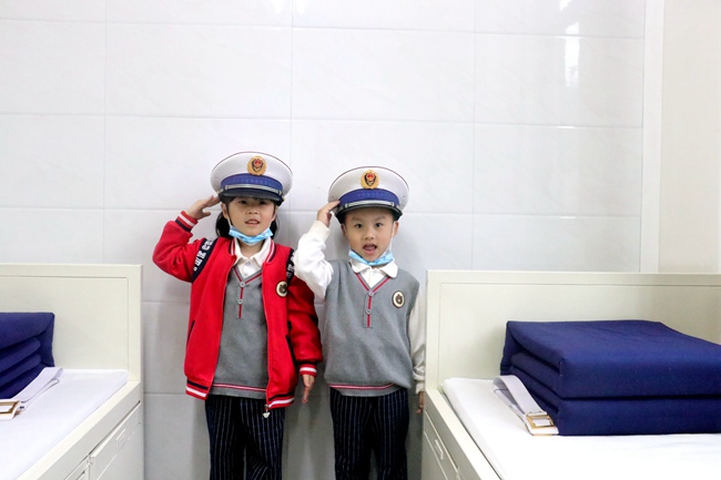 幼兒園小朋友在參觀指戰員宿舍時，戴上大檐帽，向指戰員敬禮。福安市森林消防大隊供圖