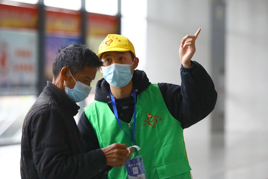 青年志願者向旅客介紹乘車站台和注意事項。