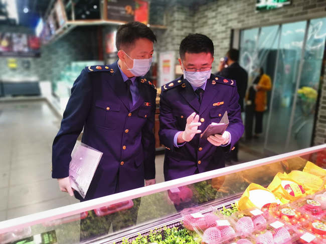 湖裡區市場監管局執法人員使用手機對進口冷鏈產品溯源二維碼進行核驗。廈門市市場監管局供圖