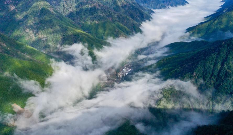 武夷断裂带峡谷内云雾缭绕，村庄若隐若现。