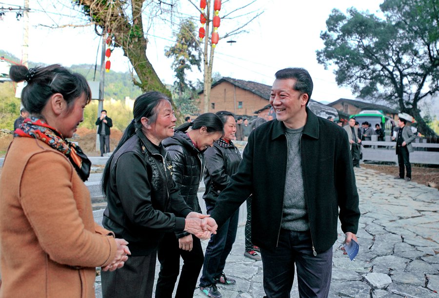 時任政和縣委書記的廖俊波（前右）在石圳村與創業婦女握手交談（2015年3月20日攝）。新華社發（李左青攝）