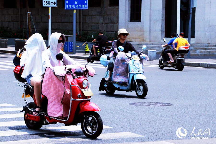 在福州市街头，随处可见市民出行“全副‘捂’装”，做好了防暑防晒的保护措施。人民网 刘卿摄