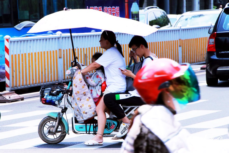 电动自行车上安装的遮阳伞也成为防晒“神器”。人民网 刘卿摄