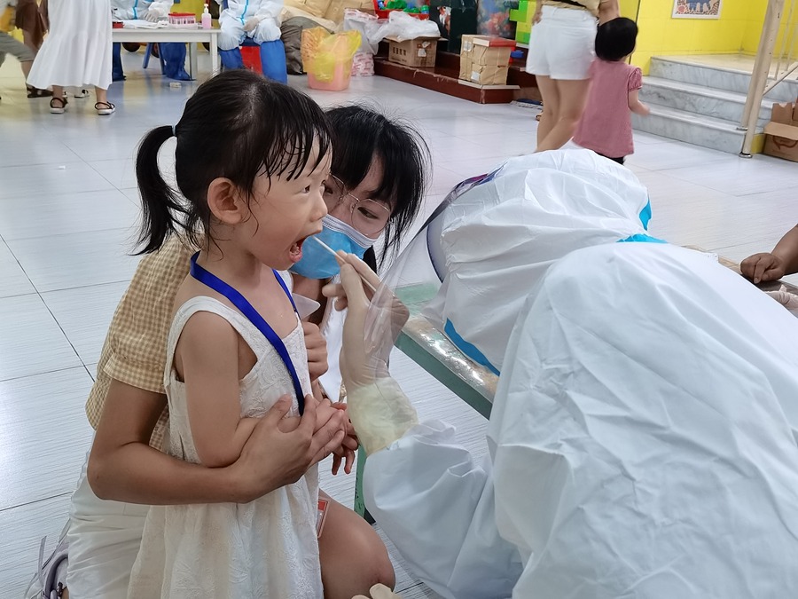 9月15日，在德化縣雙魚幼兒園，醫護人員為小朋友進行咽拭子採集。徐麗琳攝