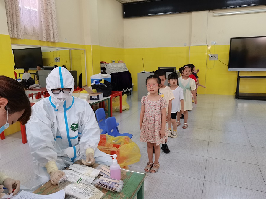 9月15日，在德化縣雙魚幼兒園，醫護人員為小朋友進行咽拭子採集。徐麗琳攝
