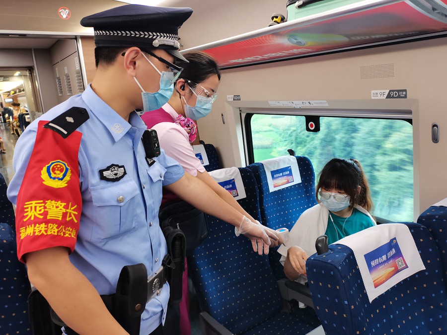 民警在G304次列车上配合客运班组做好旅客测温。董俊哲摄