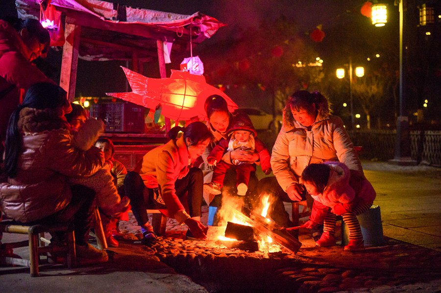烤着篝火，村民们聚在一起闲聊日常。罗道荣摄