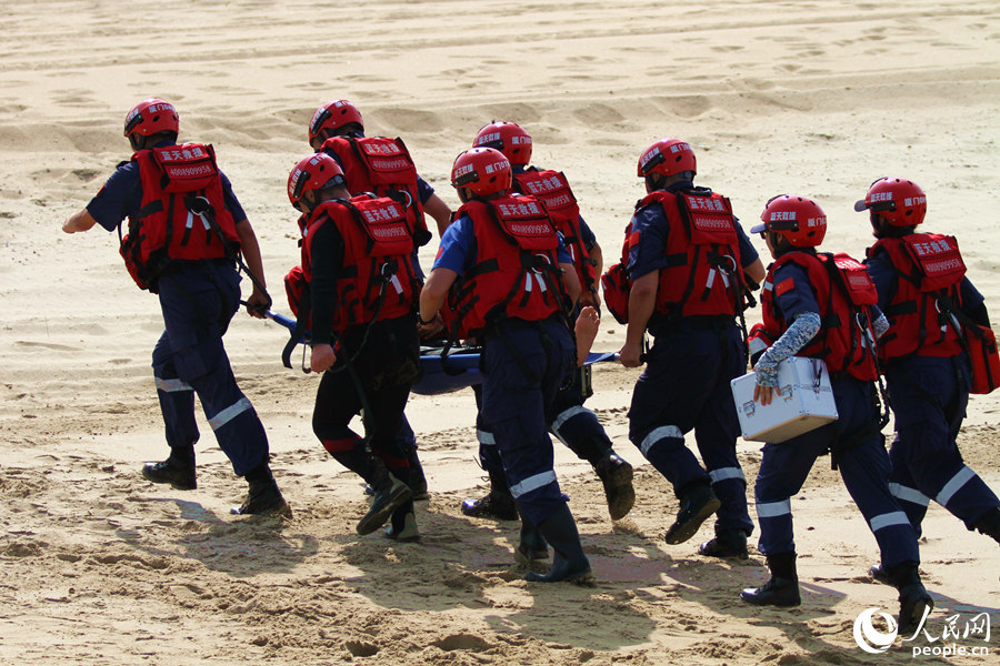 救援人员用担架将“落水者”送往救护车。人民网 陈博摄