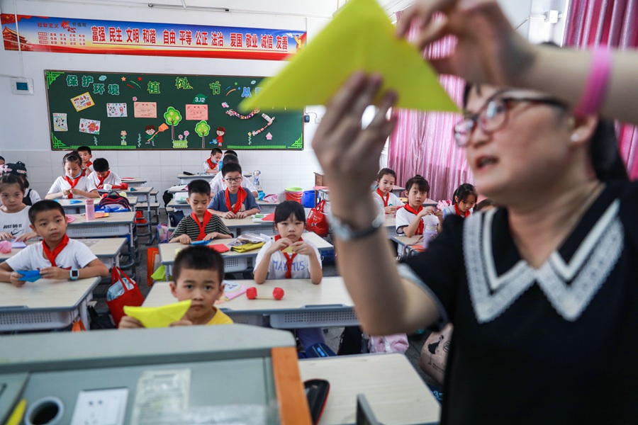 学生在老师指导下做手工折纸。郑文典摄