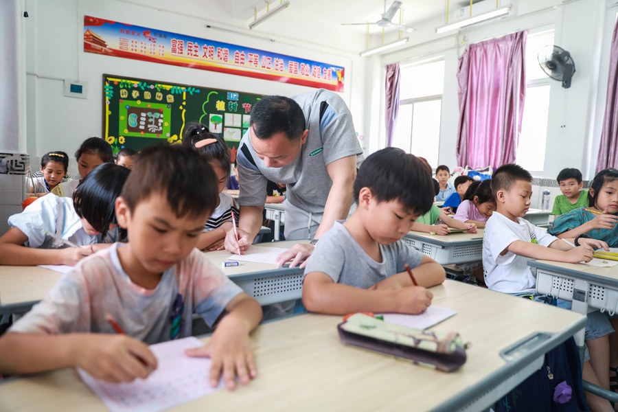 老师指导学生练习硬笔书法。郑文典摄