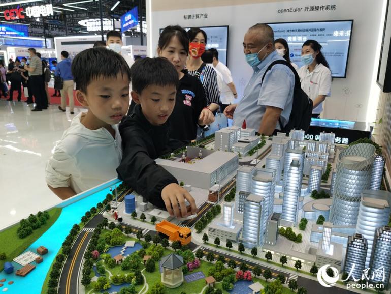 第五届数字中国建设成果展上，孩子们正在围观城市规划模型。人民网 刘卿摄