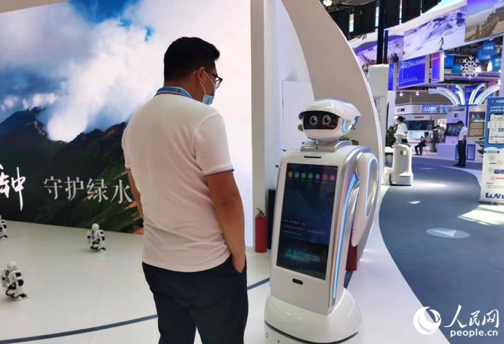 第五届数字中国建设成果展上，参展者正在体验人工智能机器人服务。人民网 刘卿摄