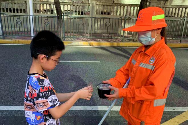 参与活动的孩子为社区周边环卫工人送上四果汤。园山社区供图