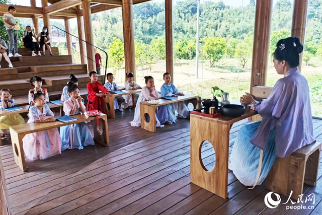 村民鄧雪梅退休后“想為村子做點兒事”，於是將適齡兒童組織起來穿漢服、教授三字經等傳統文化，成了村裡一景。人民網 劉卿攝