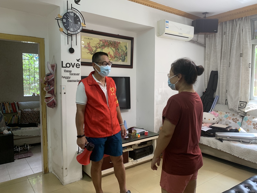 近邻监督员刘建明入户宣导居民进行核酸检测。思明区融媒体中心供图
