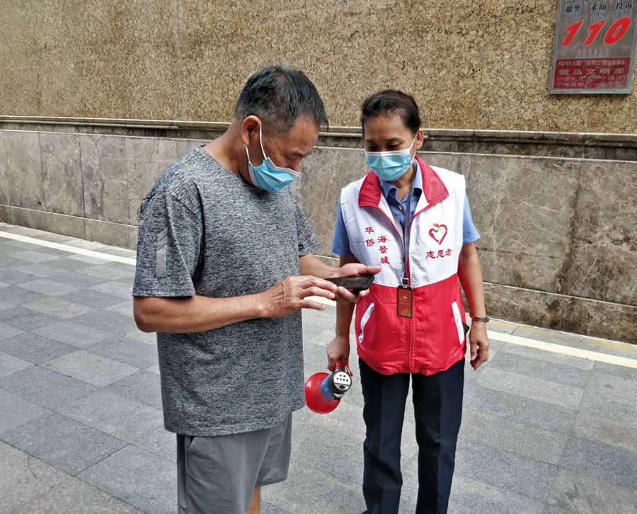 近邻监督员黄济美查验居民核酸检测证明。思明区融媒体中心供图
