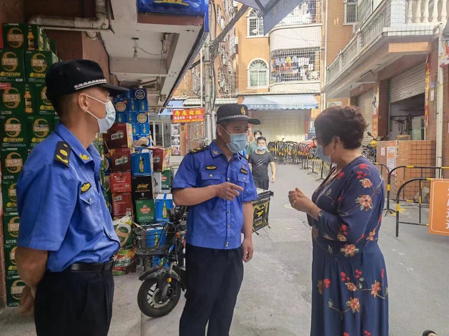 厦门“城管蓝”巡查市容市貌时向市民宣传疫情防控。厦门市执法局供图