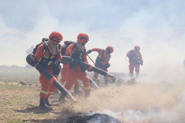班組滅火行動中,消防員正在清理火線。王治康攝