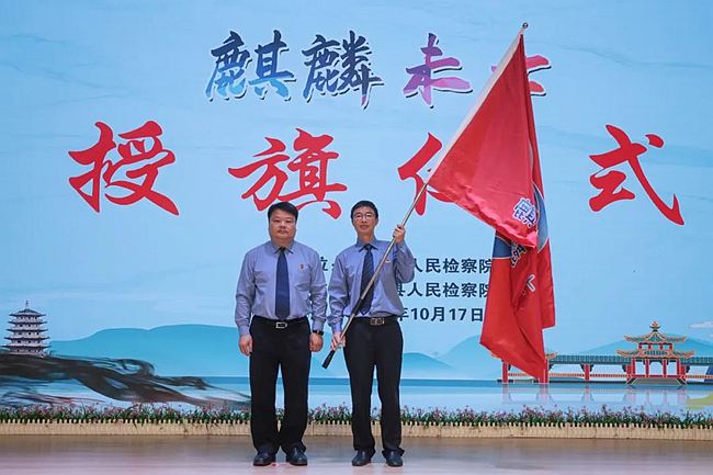 董斌向江长擎授予“麒麟未士”队旗。尤溪县检察院供图