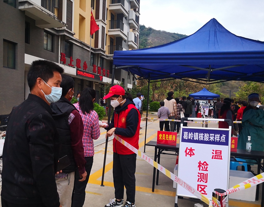 党员志愿者在核酸检测现场协助。王光伟摄