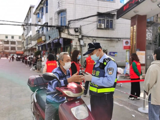 公安干警在核酸检测现场指导老人使用健康码。长乐区融媒体中心供图