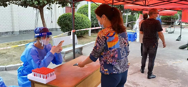 长乐区直机关党员干部对采样群众进行检测登记。长乐区融媒体中心供图