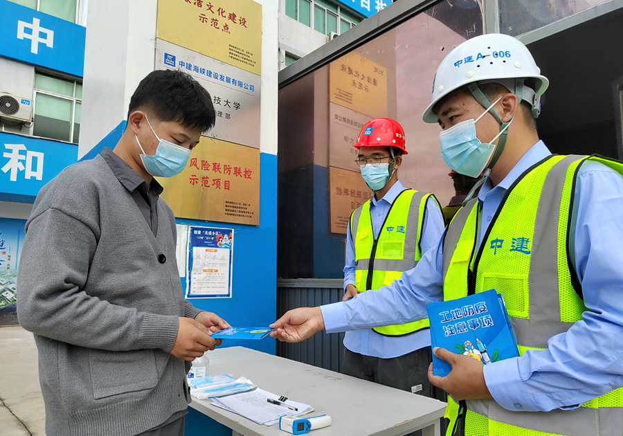 中建海峡福耀科技大学项目青年志愿者发放工地防疫宣传手册，宣传疫情防控知识