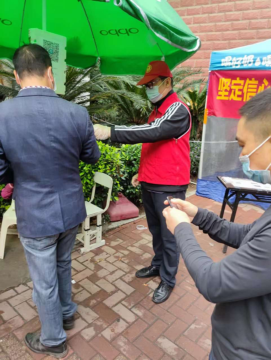 福建海峡银行党员志愿者协助小区进行体温检测、健康码查验。