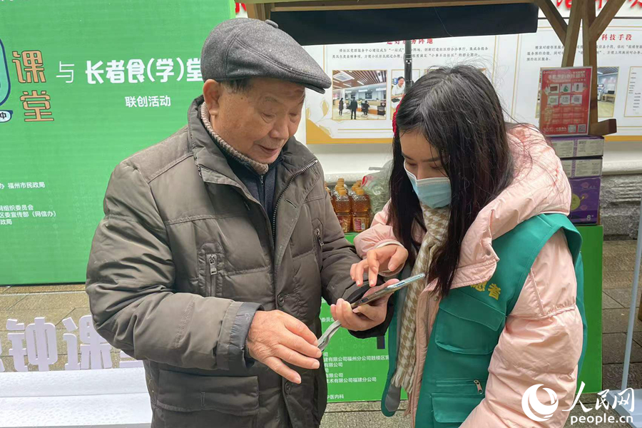 志愿者教社区老人使用手机软件。人民网 林盈摄