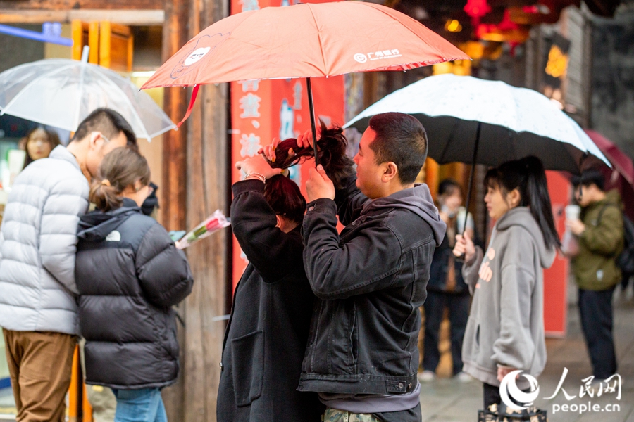 三坊七巷内，丈夫一边打伞，一边为妻子扎头发。康磊摄