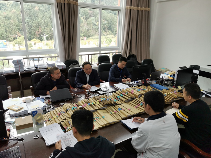 郭伟民（前排中间）与同事研究堆积如山的案卷。福州市公安局供图