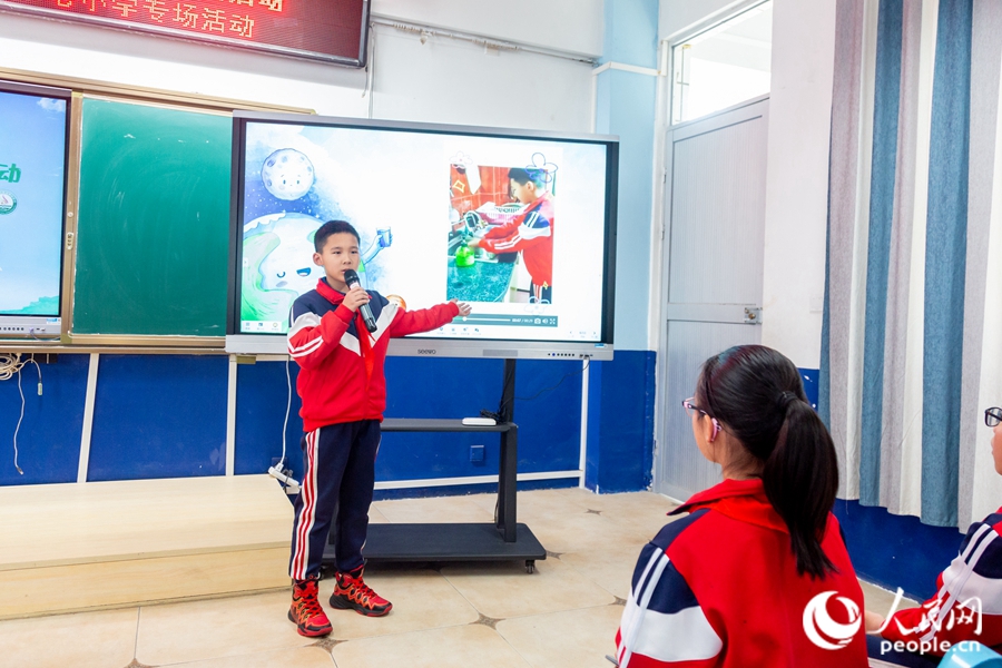 一名同学正绘声绘色地介绍自己的节水绘画作品。实习生康磊摄