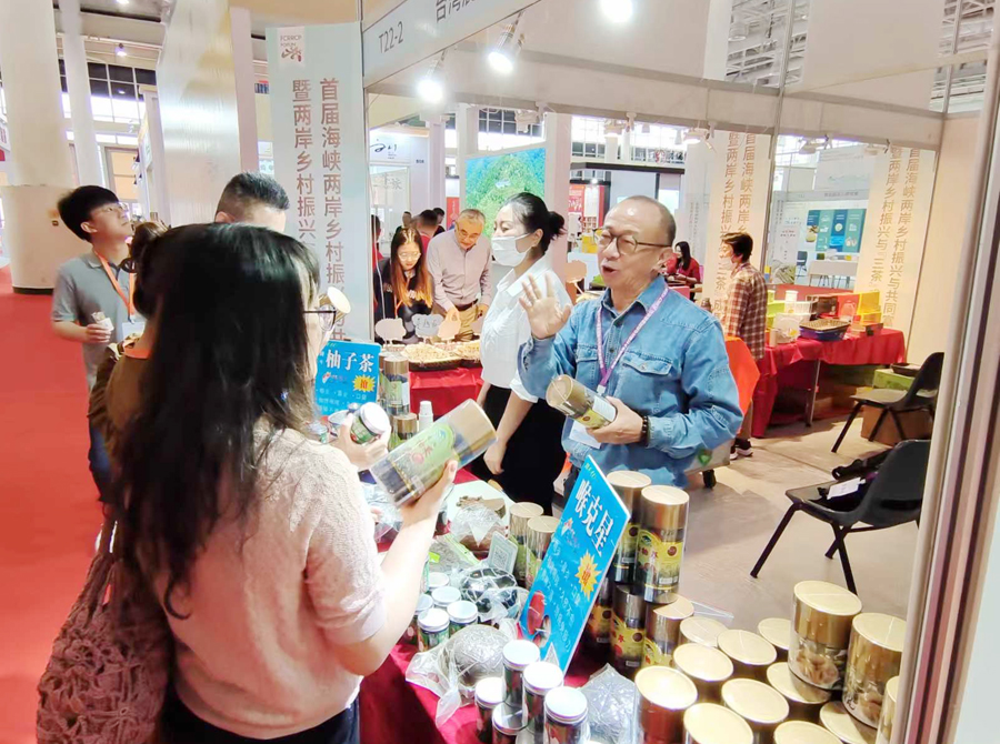来自台湾许先生(右一)现场为嘉宾及游客介绍他经营的柚子参。林林摄